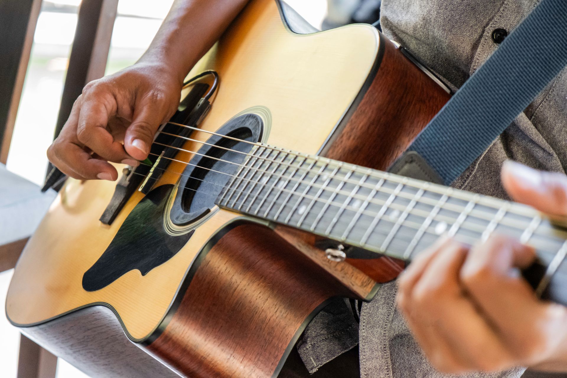A person is playing an acoustic guitar on a balcony.