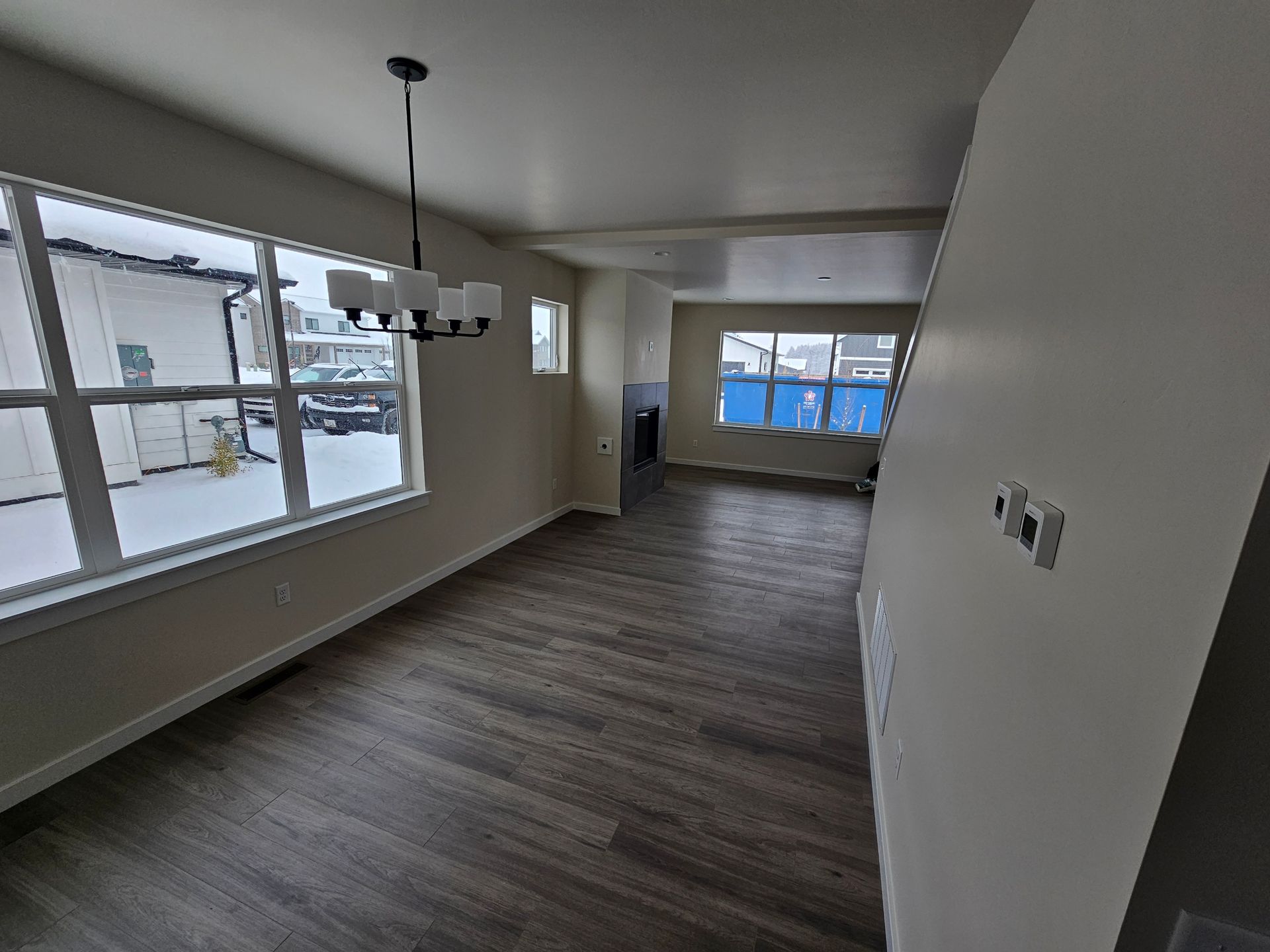 A closet with a window and shelves in a house under construction.