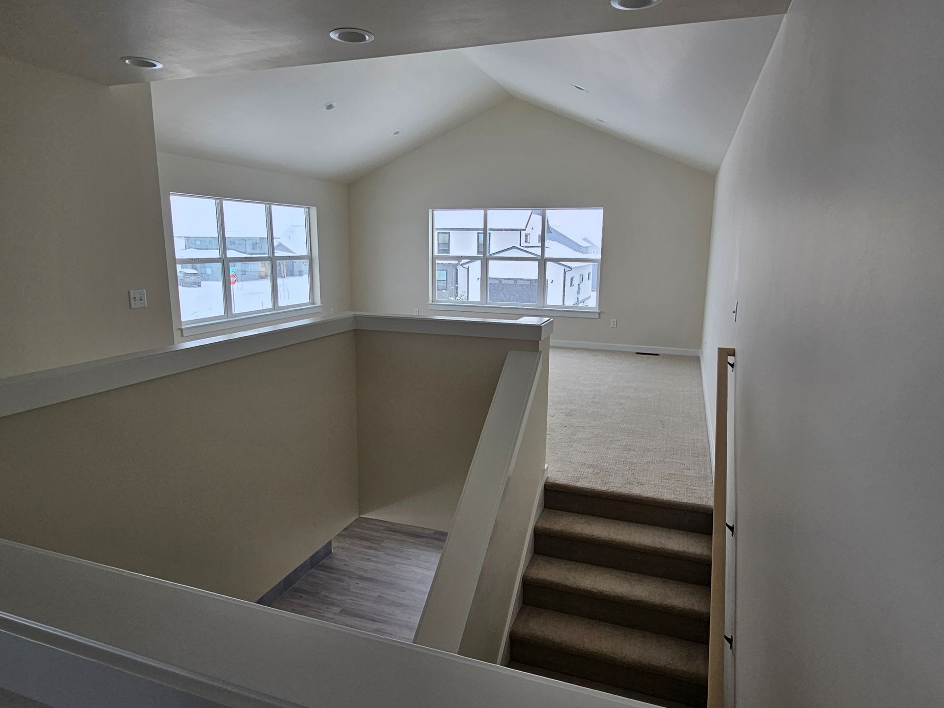 A house with a lot of windows is covered in snow.