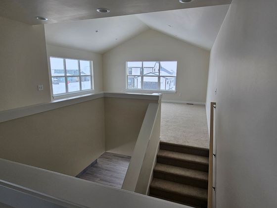 A house with a lot of windows is covered in snow.