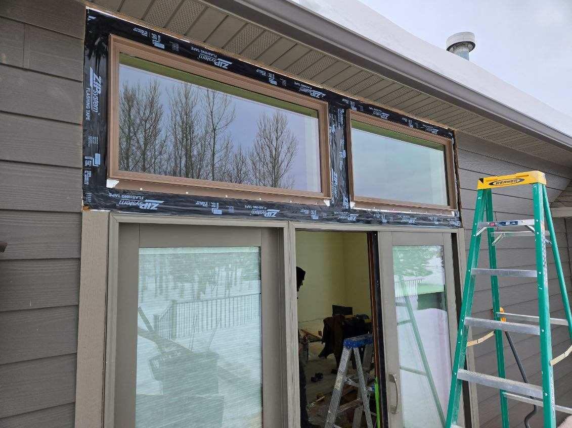 A ladder is sitting next to a window on a house