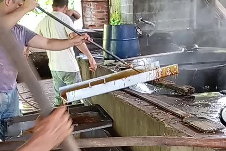 A group of men are cooking food in a kitchen.