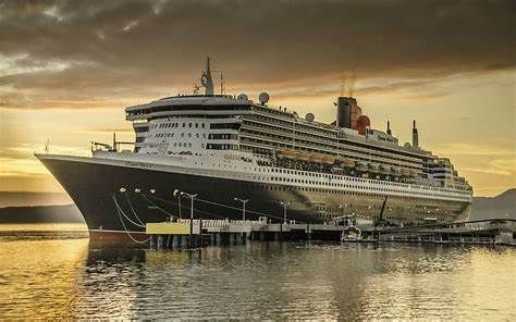 A large cruise ship is docked at a dock at sunset.