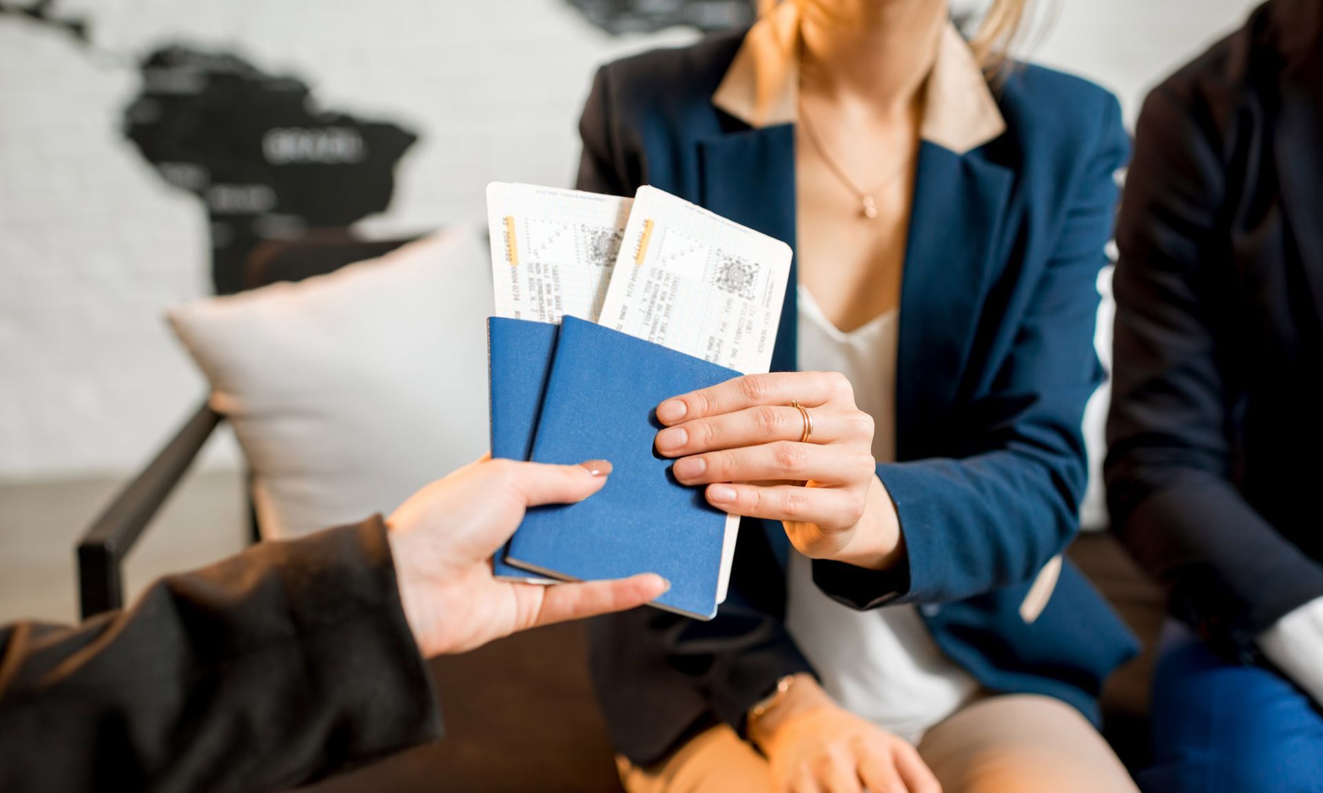 A woman is holding a passport and airline tickets.