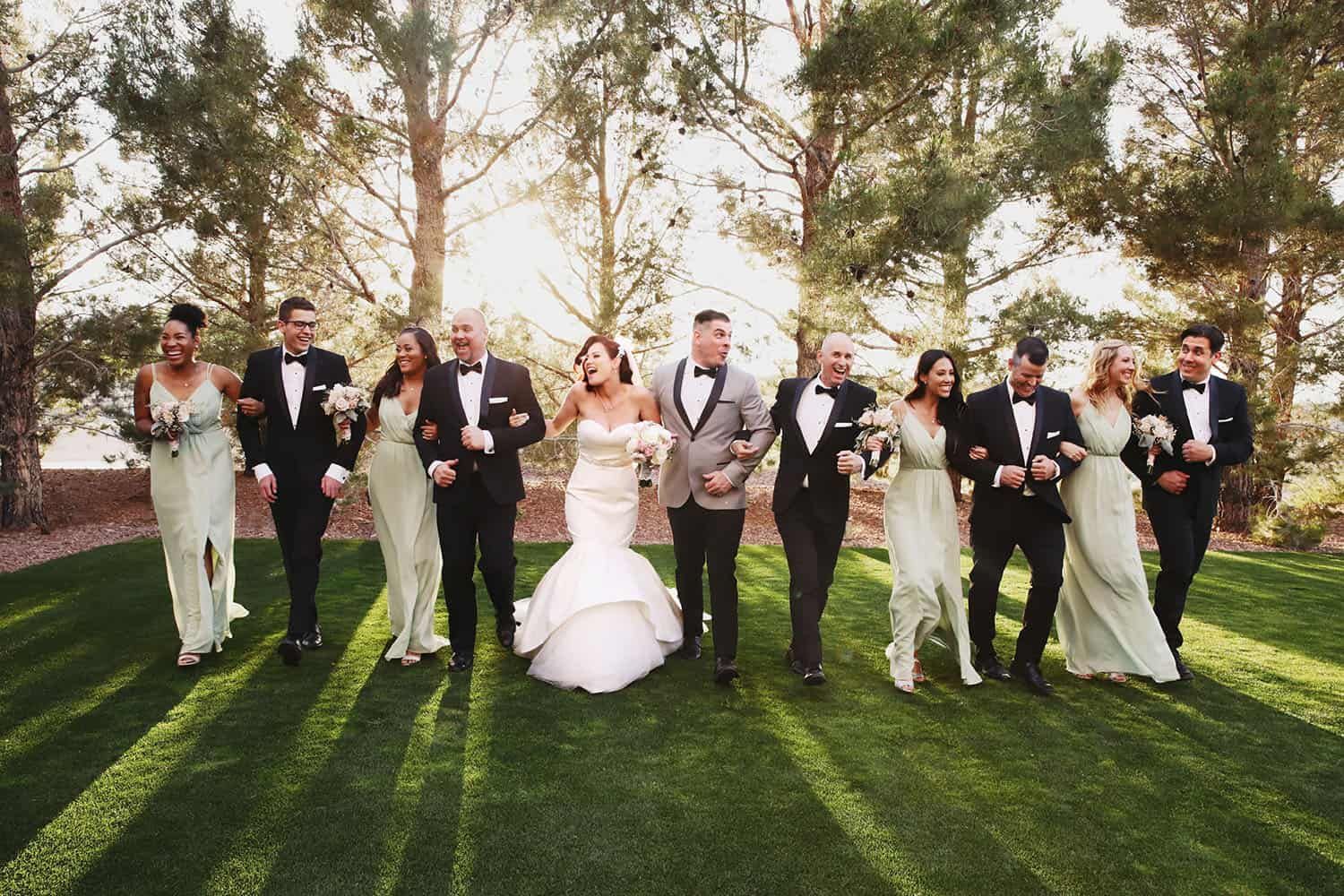 A bride and groom are walking with their wedding party.