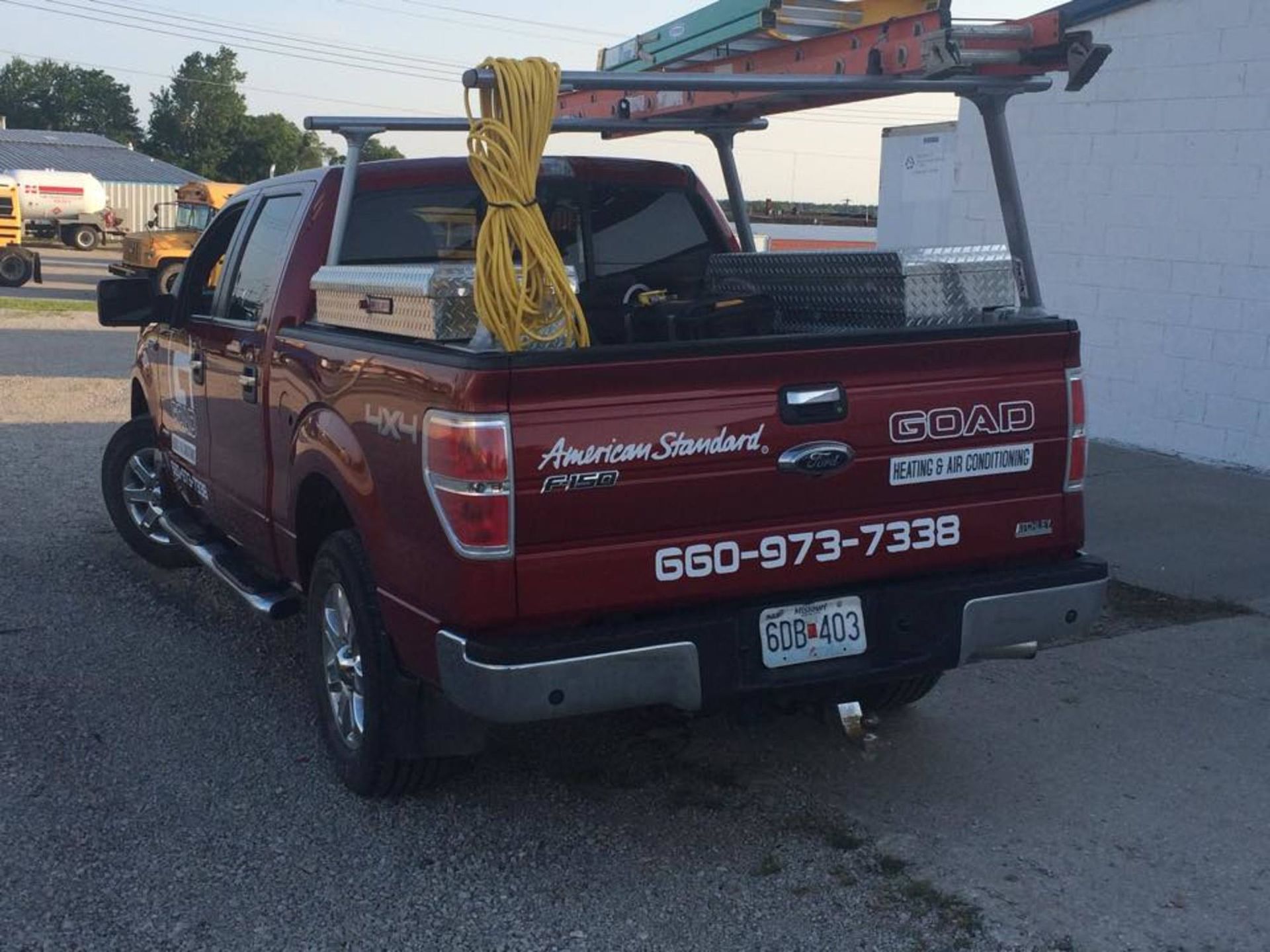 A red ford truck is parked in front of a white building