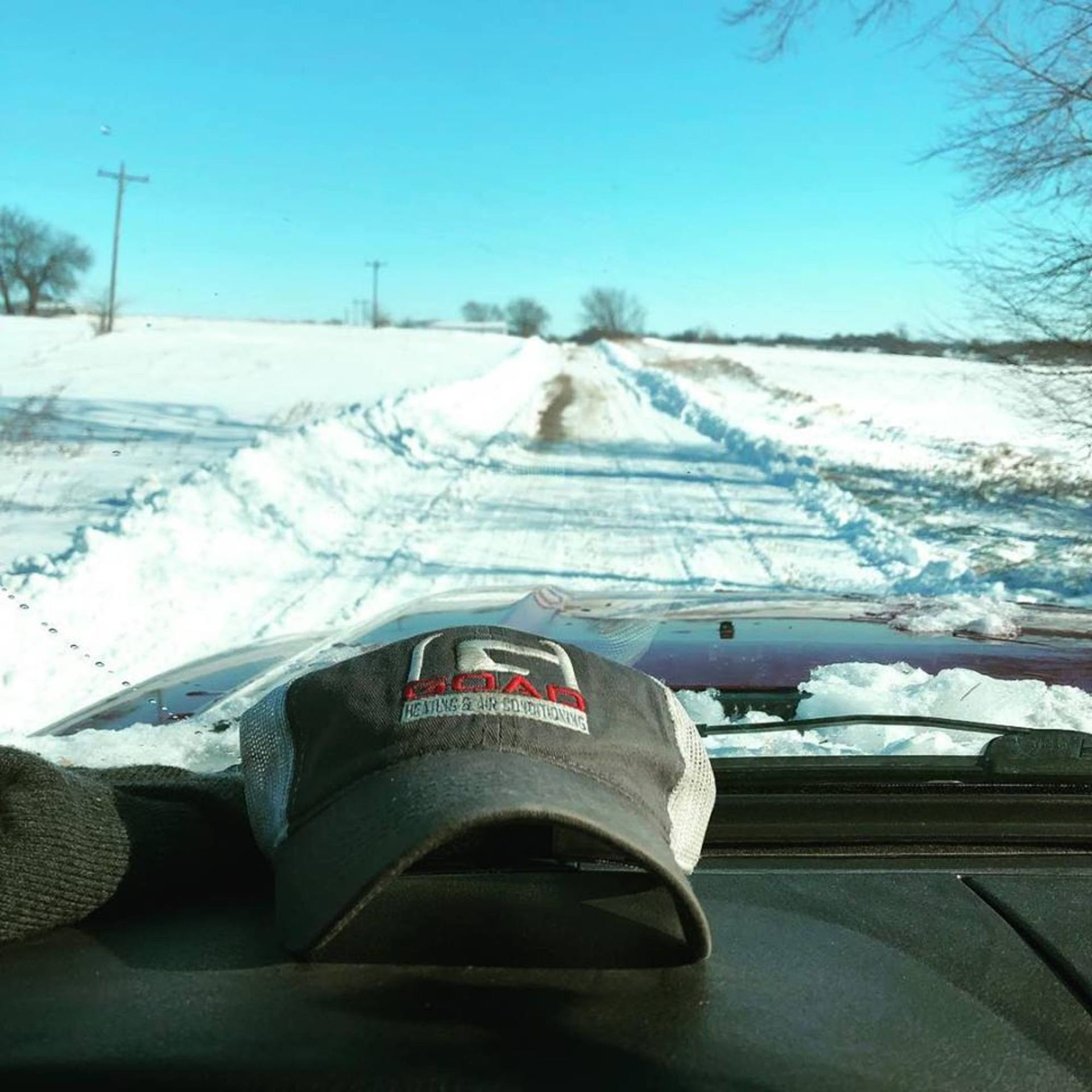 A hat with the letter r on it sits on the dashboard of a car
