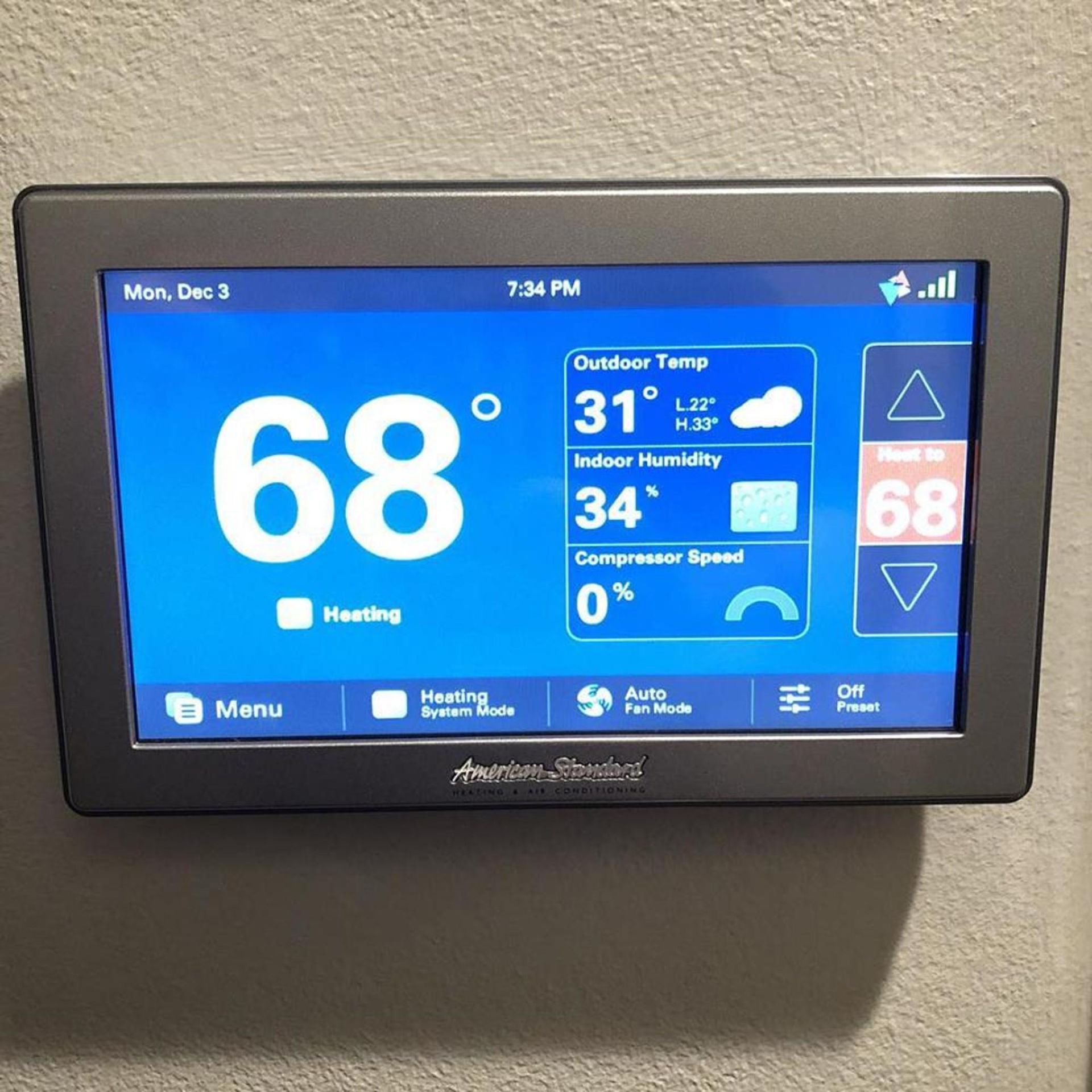 A thermostat displays the temperature at 68 degrees