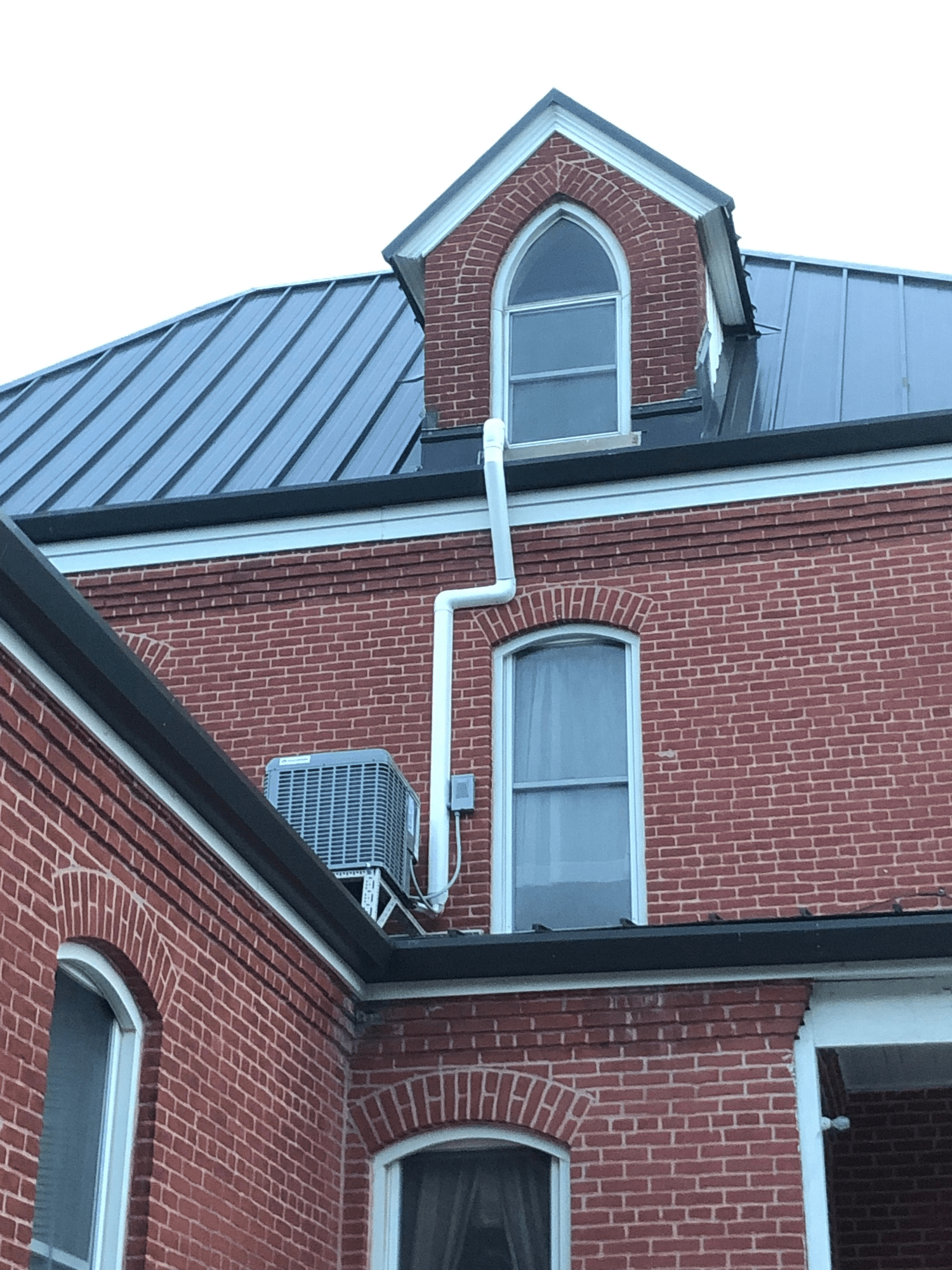 A brick building with a black roof and a window