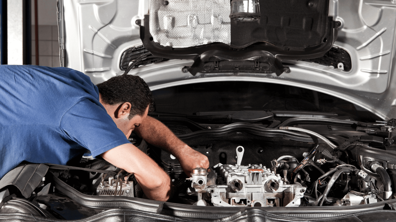 A mobile mechanic under the hood of a car.