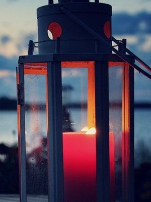 A wooden walkway leading to a gazebo overlooking a body of water at sunset.