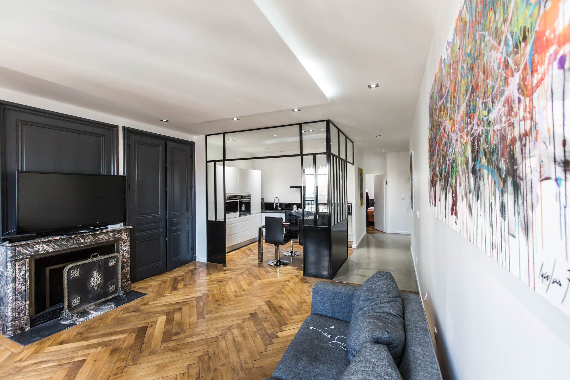 Espace salon cuisine rénové dans un appartement avec parquet ancien à Lyon