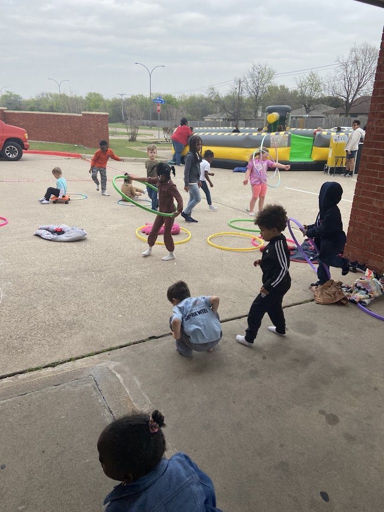 A group of children are playing with hula hoops in a parking lot.