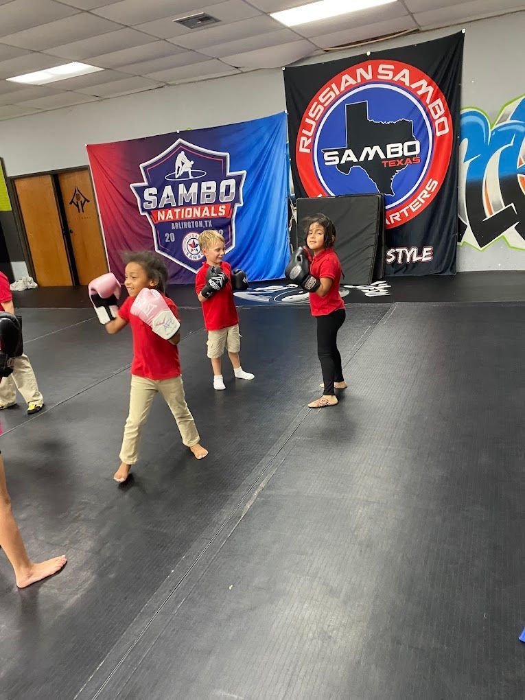 A group of young children are practicing martial arts in a gym.