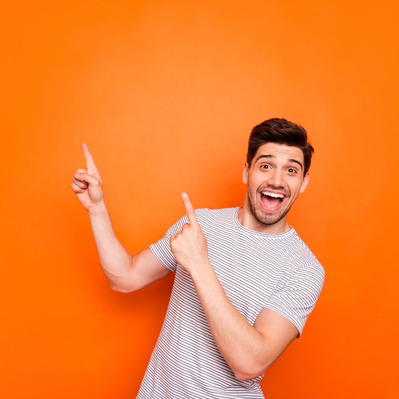 A man is pointing up with his finger against an orange background.