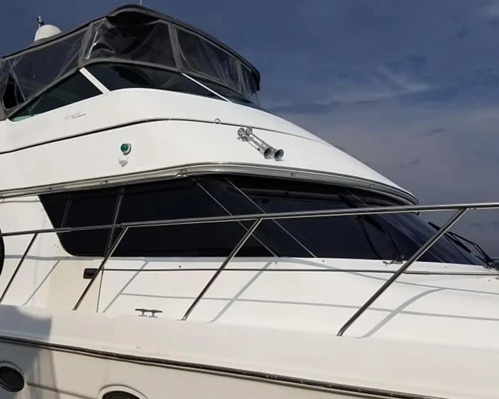 White motor yacht with tinted windows, stainless steel rails, and a radar dome.