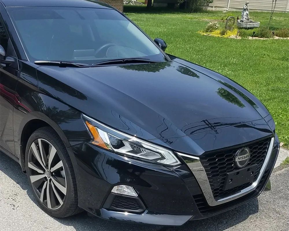 Dark blue Nissan Altima car parked outside on a sunny day.