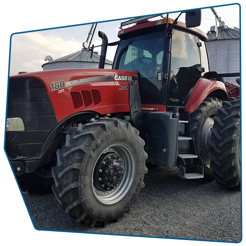 Red Case IH 180 tractor parked on gravel, with silos in the background. Red Case IH 180 tractor parked on gravel, with silos in the background.
