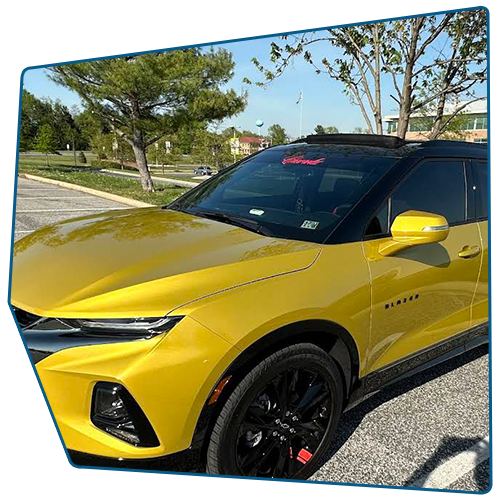 Yellow Chevrolet Blazer with black accents parked outdoors. Yellow Chevrolet Blazer with black accents parked outdoors.