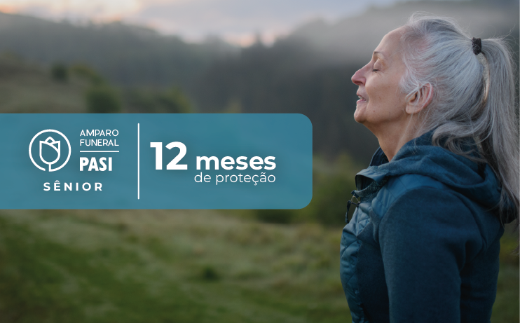 Uma mulher de cabelos grisalhos está parada em um campo com os olhos fechados.