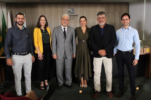 Um grupo de pessoas está posando para uma foto em uma sala.