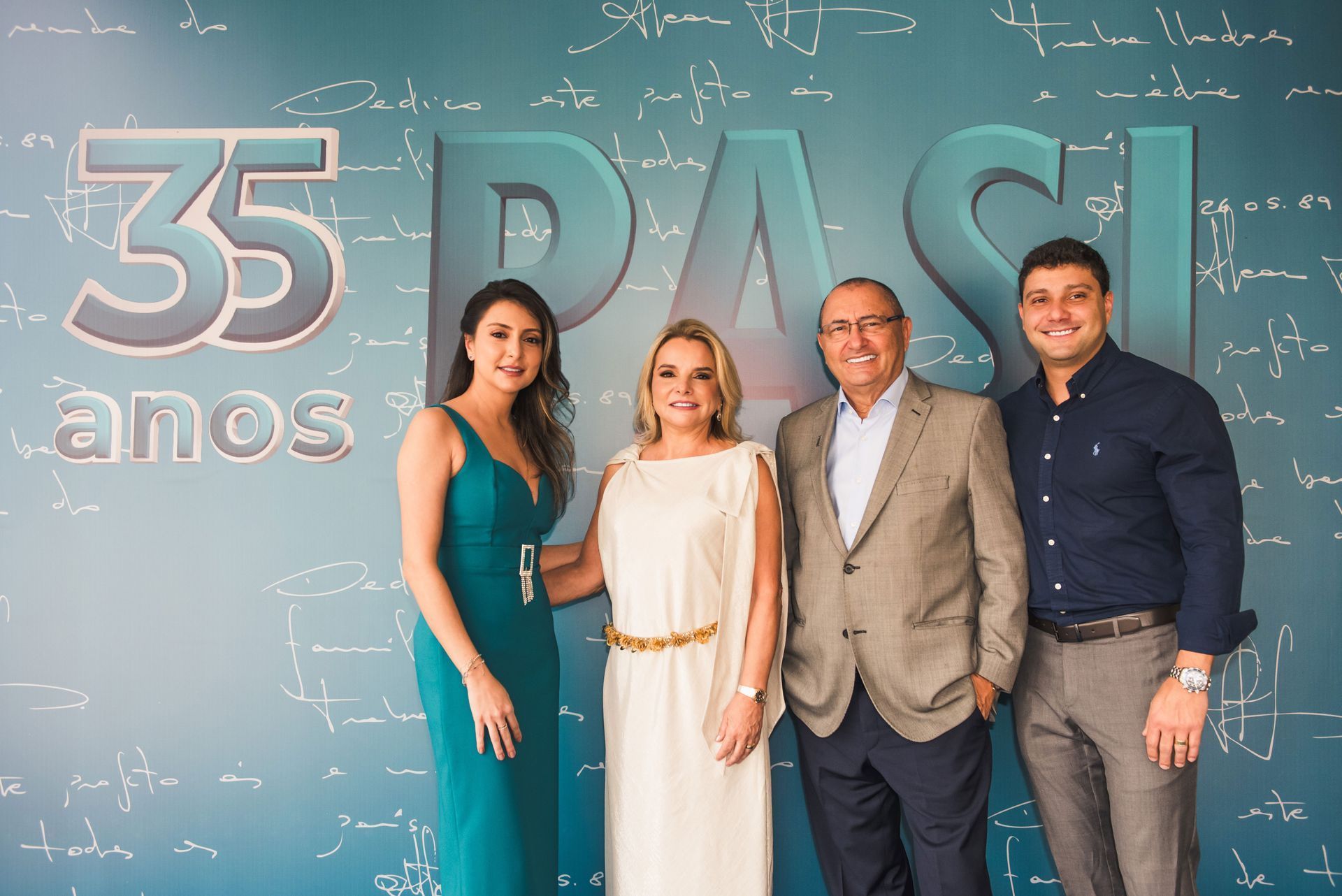 Um grupo de pessoas em pé em frente a uma placa que diz 35 anos