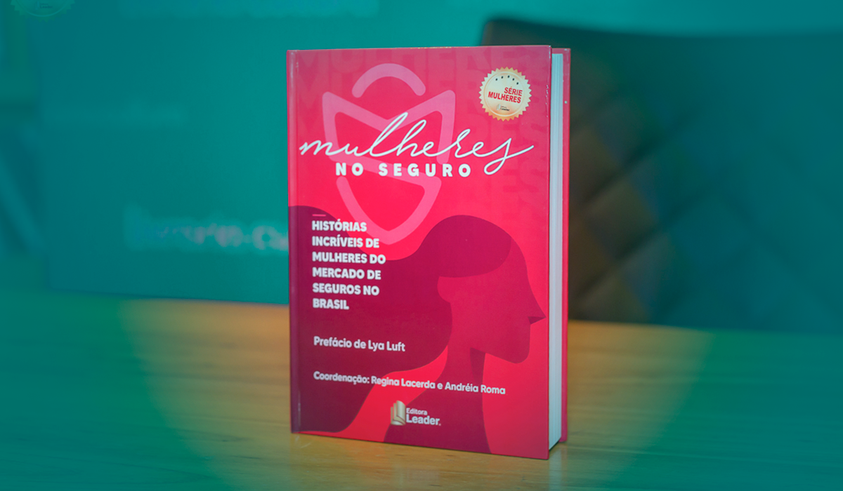 Um livro vermelho está sobre uma mesa de madeira.