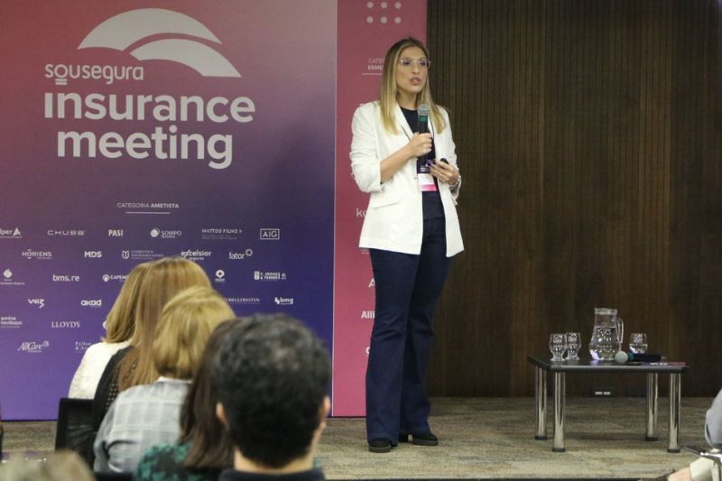 Uma mulher está fazendo uma apresentação em uma reunião de seguros
