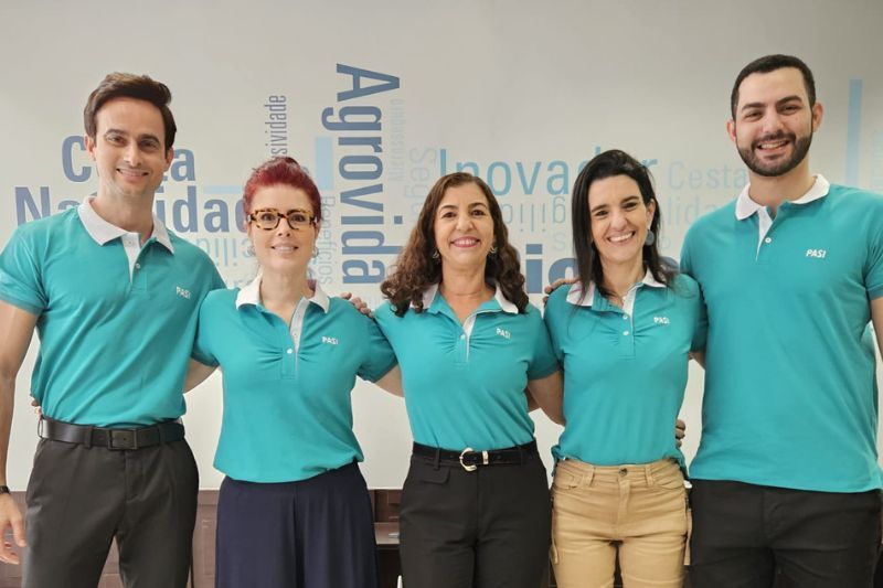 Um grupo de pessoas vestindo camisas polo azuis estão posando para uma foto.
