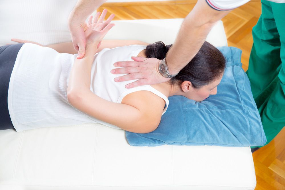 Chiropractor Massage The Female Patient Spine And Back — Dorn Method in Glenfield Park, NSW