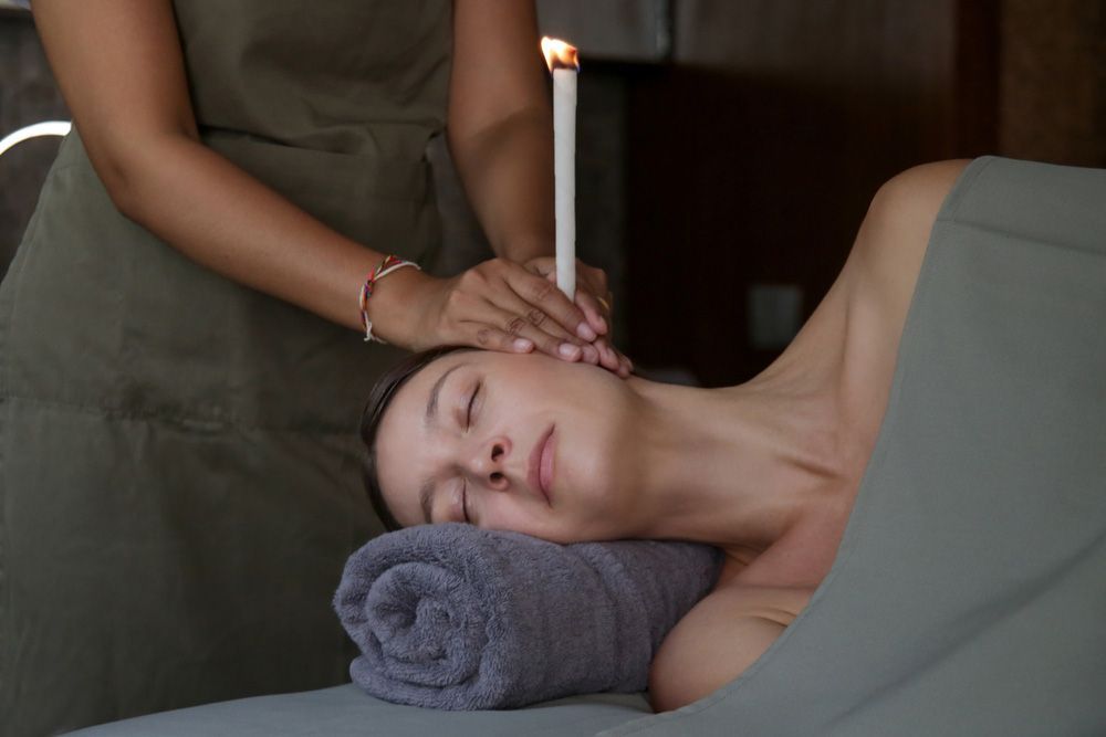 Woman Receiving Ear Candle Treatment — Master Your Journey in Glenfield Park, NSW