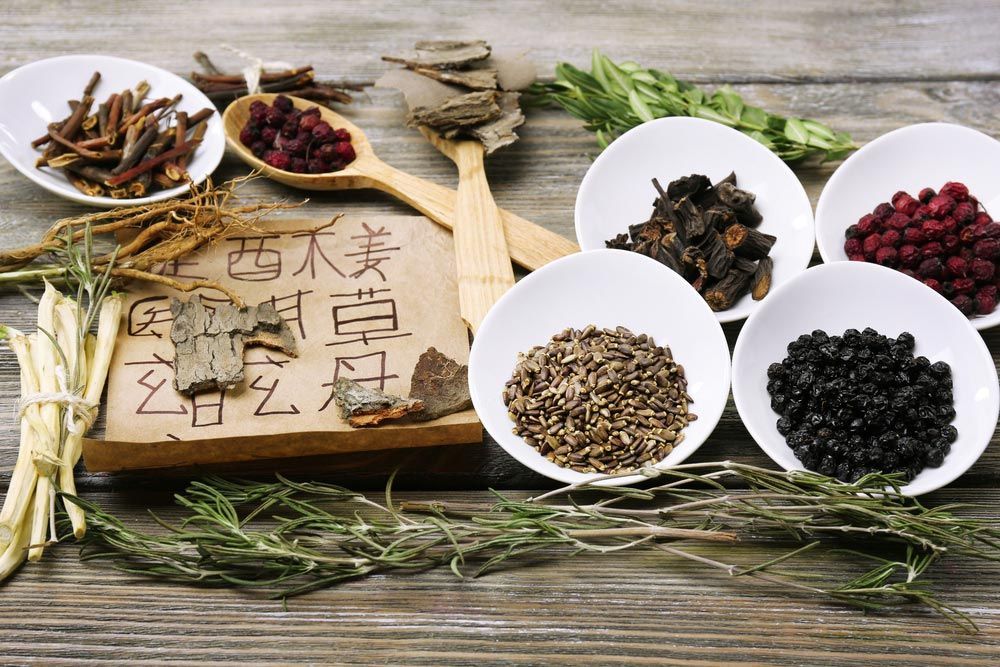 Traditional Chinese Herbal Medicine Ingredients in Small White Dishes and Wooden Spoons — Herbal & Natural Medicine in Glenfield Park, NSW