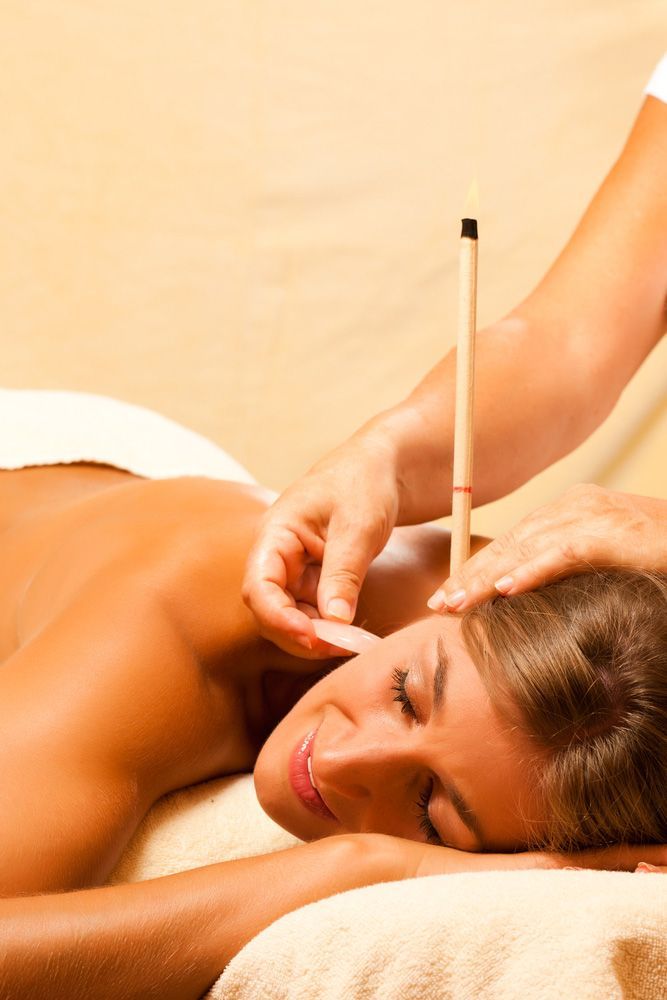 Woman with Bare Back Receiving Ear Candle Treatment — Ear Candling & Sinus Treatments in Glenfield Park, NSW
