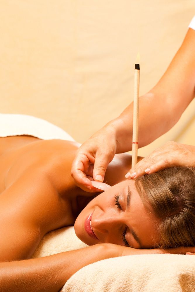 Woman with Bare Back Receiving Ear Candle Treatment — Master Your Journey in Glenfield Park, NSW