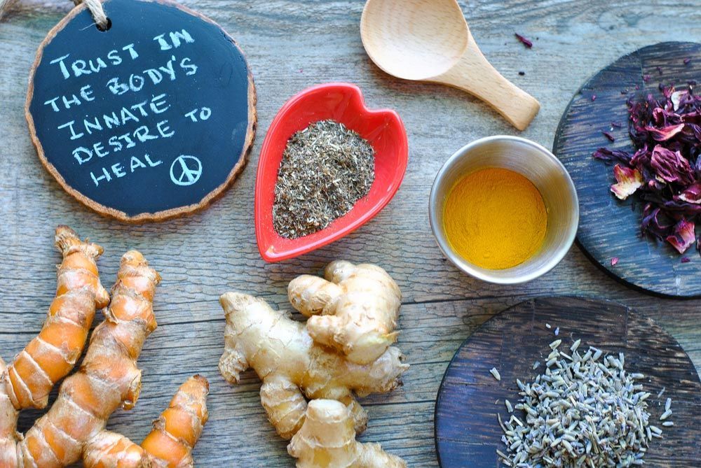 Table with Healing Ginger and Turmeric Roots And Herbs For Holistic Health Care — Iridology & Naturopathy in Glenfield Park, NSW