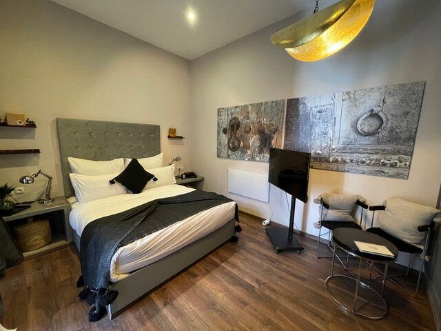 A bed with white sheets and pillows in a bedroom.