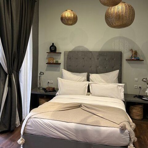 A bed with white sheets and pillows in a bedroom.