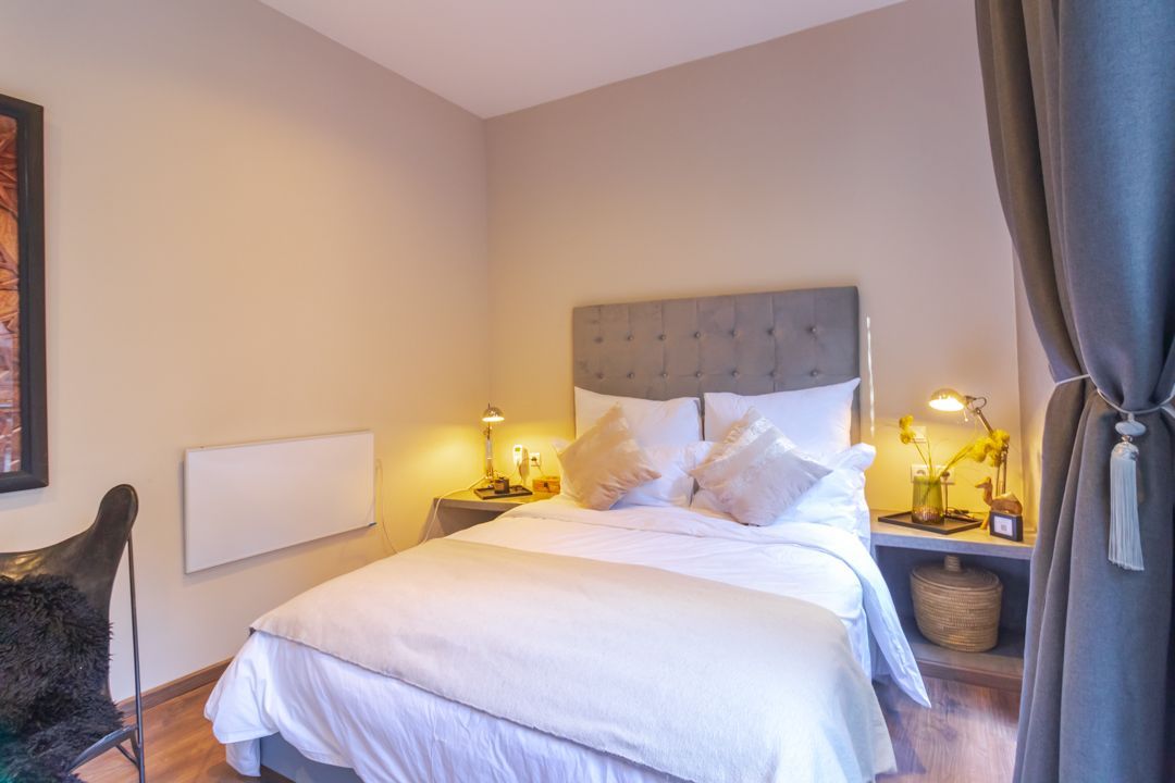 A bedroom with a large bed and a desk.