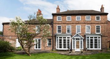 a beautiful brick building with a big lawn