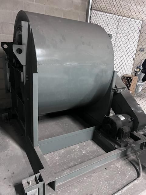 A large, gray industrial tumbler, likely for mixing or processing materials.