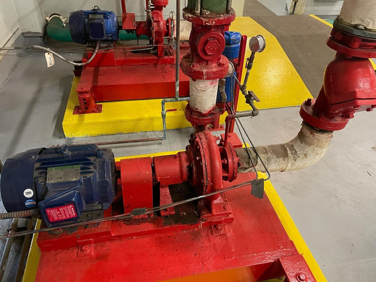 Two red boilers with blue motors on yellow platforms in an industrial setting.