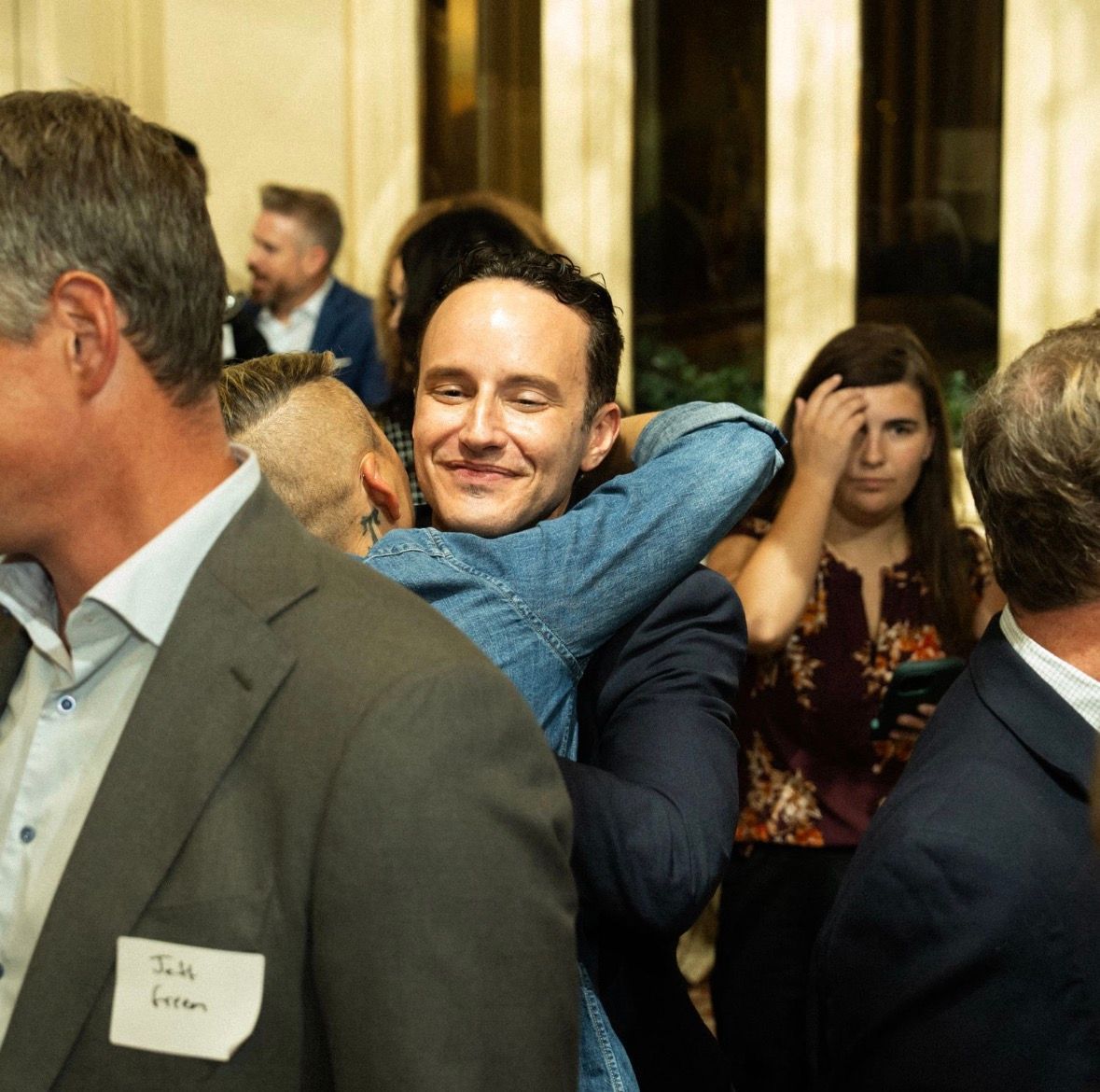 Richard hugging Iam Tucker at a campaign event; people in background.