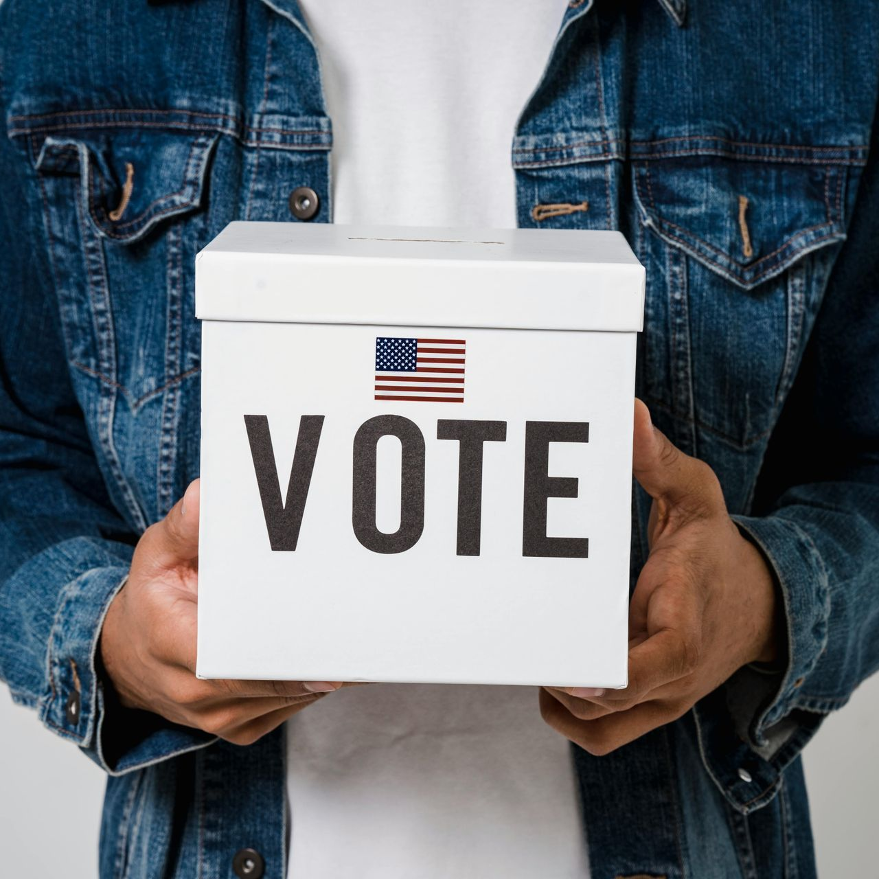 Person holding a white ballot box with 