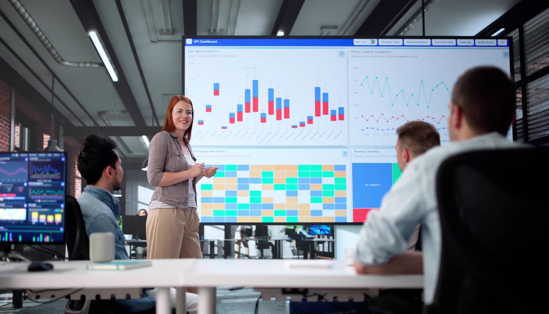 Three professionals in suits working on laptops at a desk, looking focused in a dimly lit office.