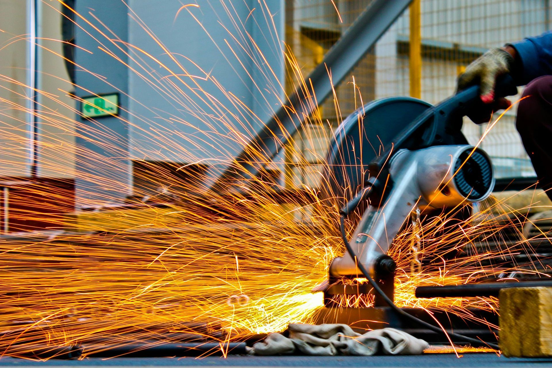 Sparks fly as a worker uses a metal cutting saw on rebar.