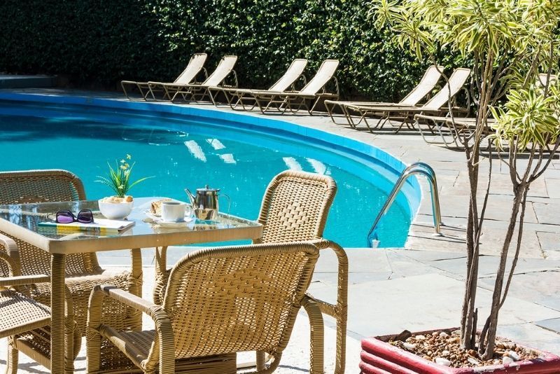 Uma mesa e cadeiras em frente a uma piscina