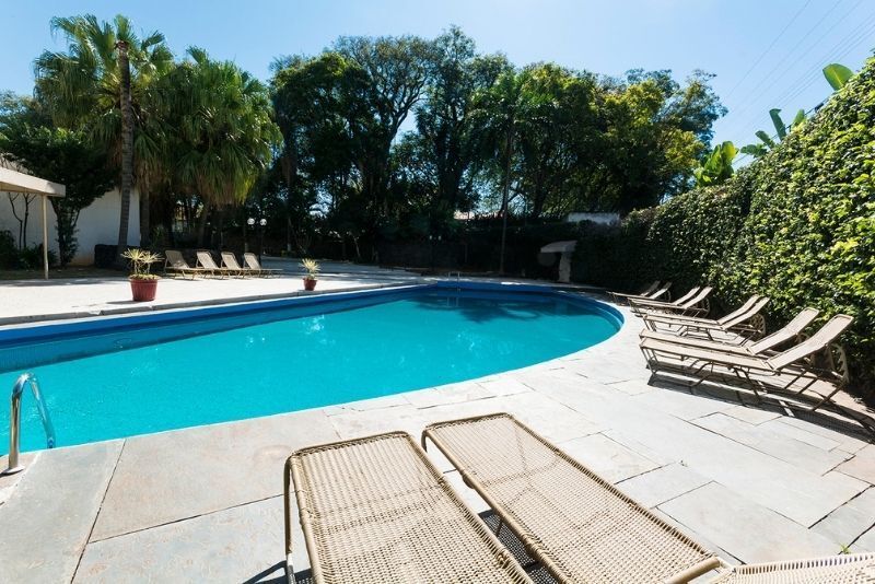 Uma grande piscina rodeada de cadeiras e árvores