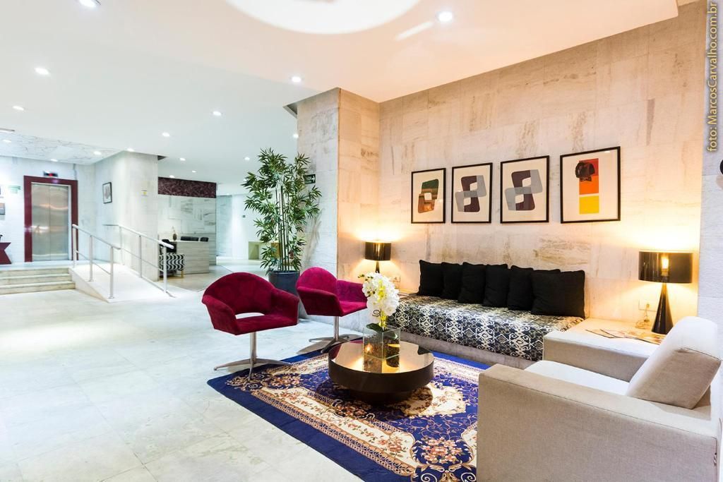 Uma sala de estar com um sofá, cadeiras, uma mesa e um tapete.