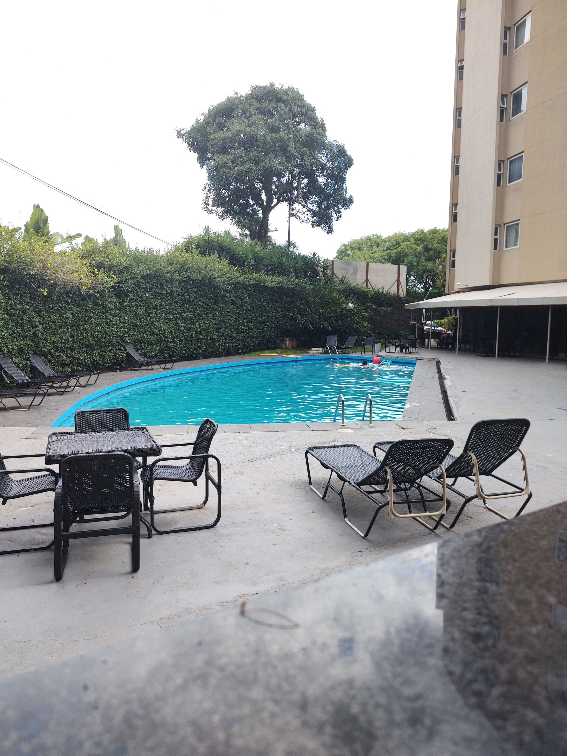 Uma grande piscina com uma mesa e cadeiras ao redor