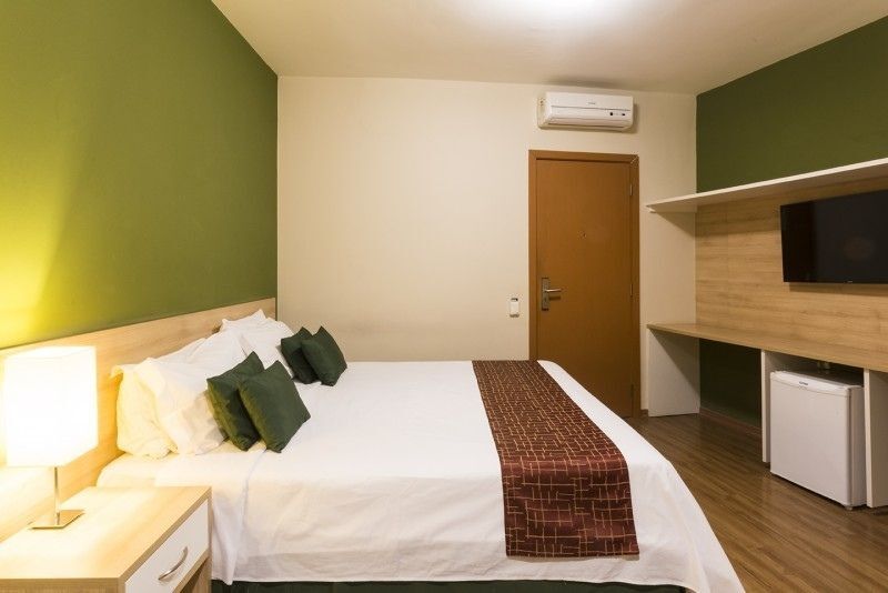 Um quarto de hotel com uma cama king size e uma TV de tela plana